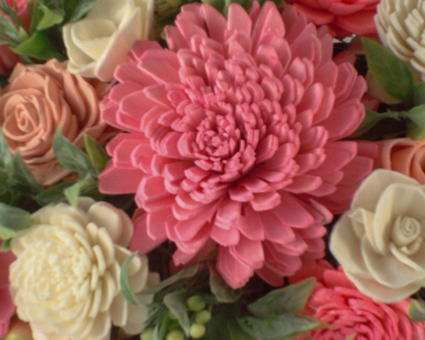 Centerpiece with hand dyed Sola flowers. Beautiful shades of pink and green wooden florals and succulents in a galvanized container