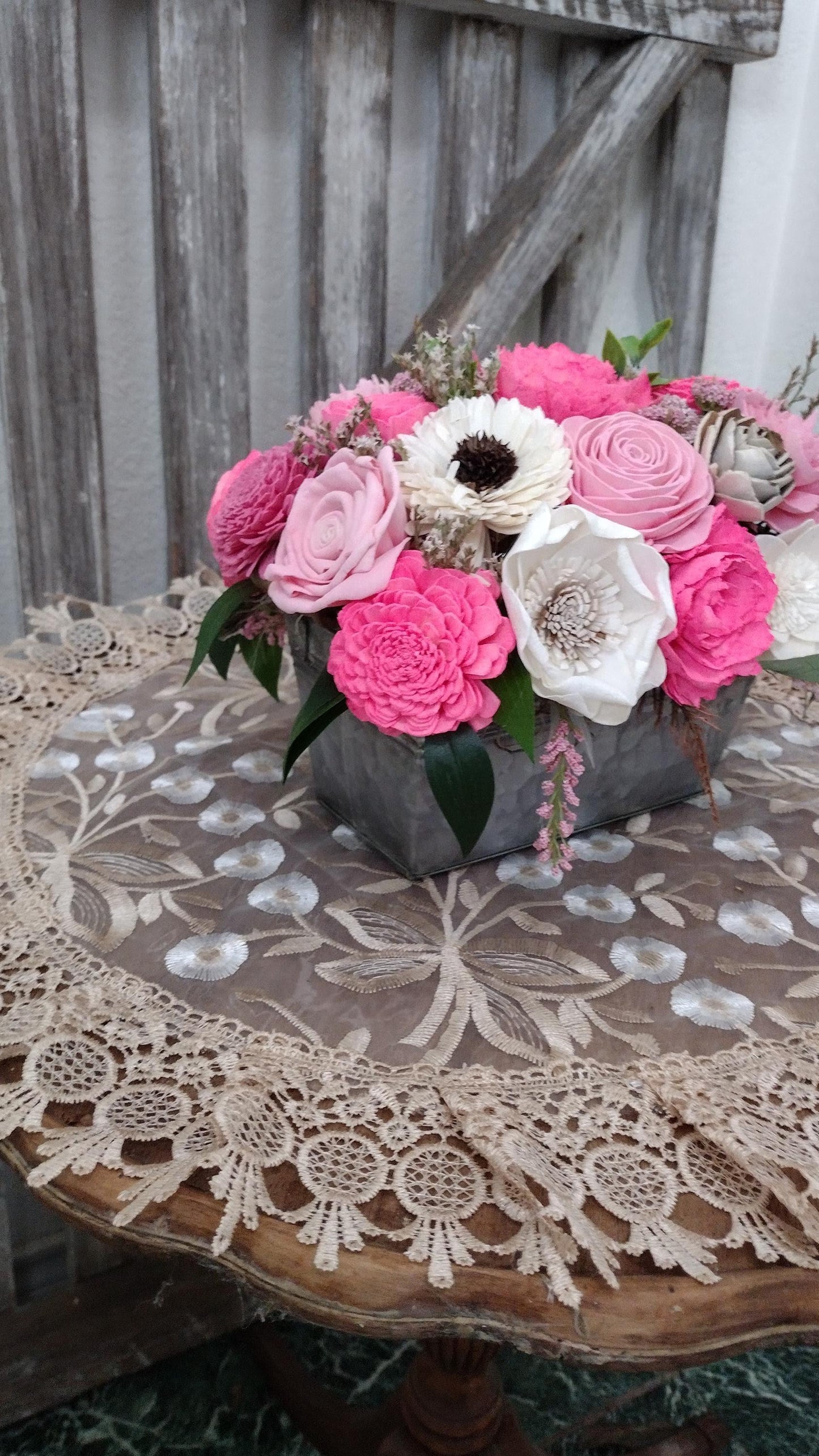 Centerpiece with hand dyed Sola flowers. Beautiful shades of pink wooden florals  in a galvanized container