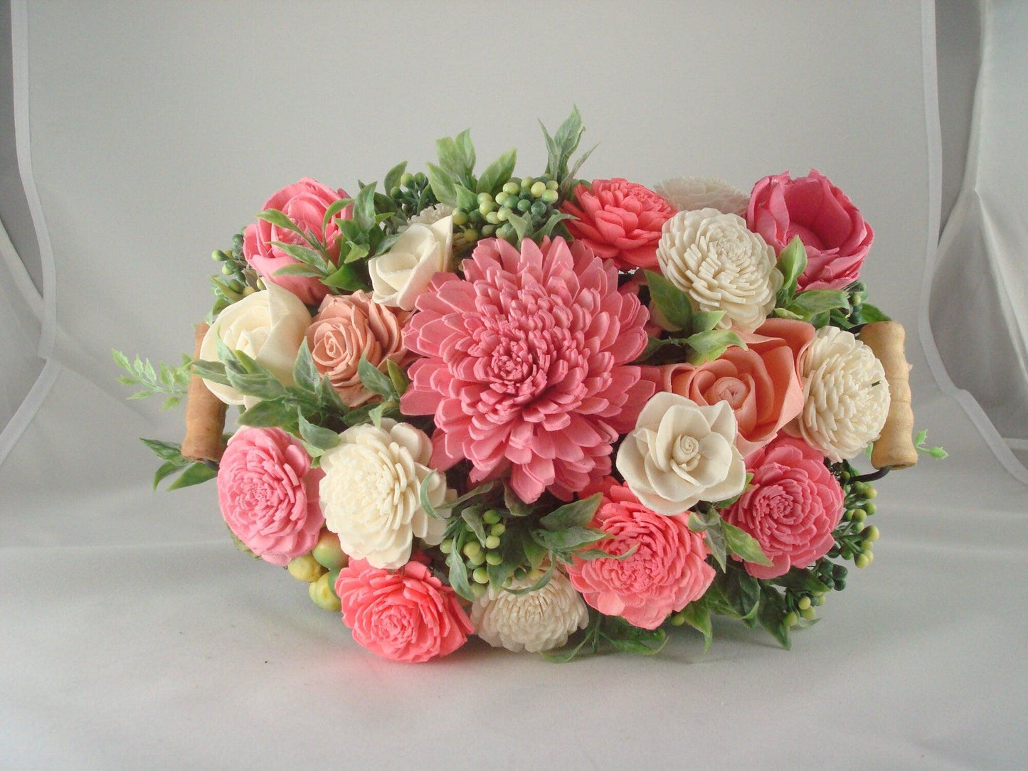 Centerpiece with hand dyed Sola flowers. Beautiful shades of pink and green wooden florals and succulents in a galvanized container