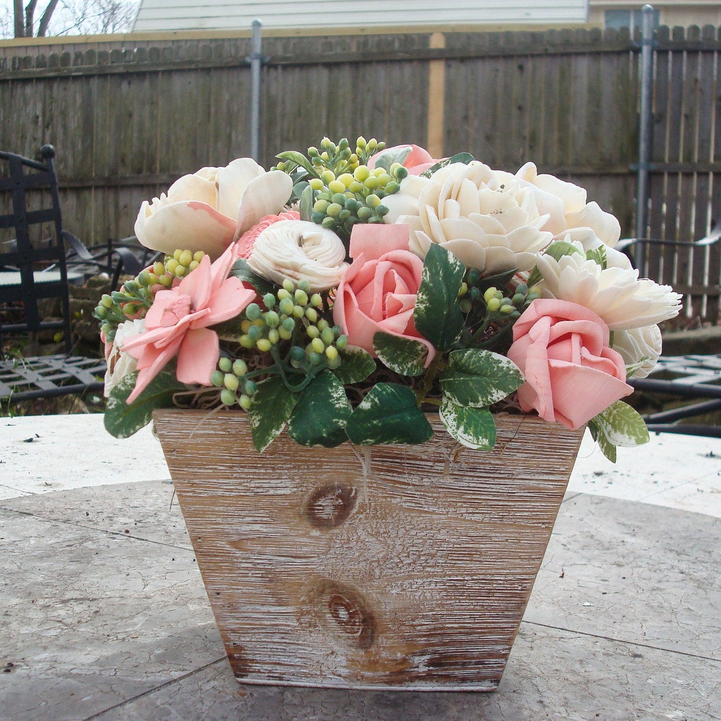 Pale pink in white Sola flowers in a  washed wood planter