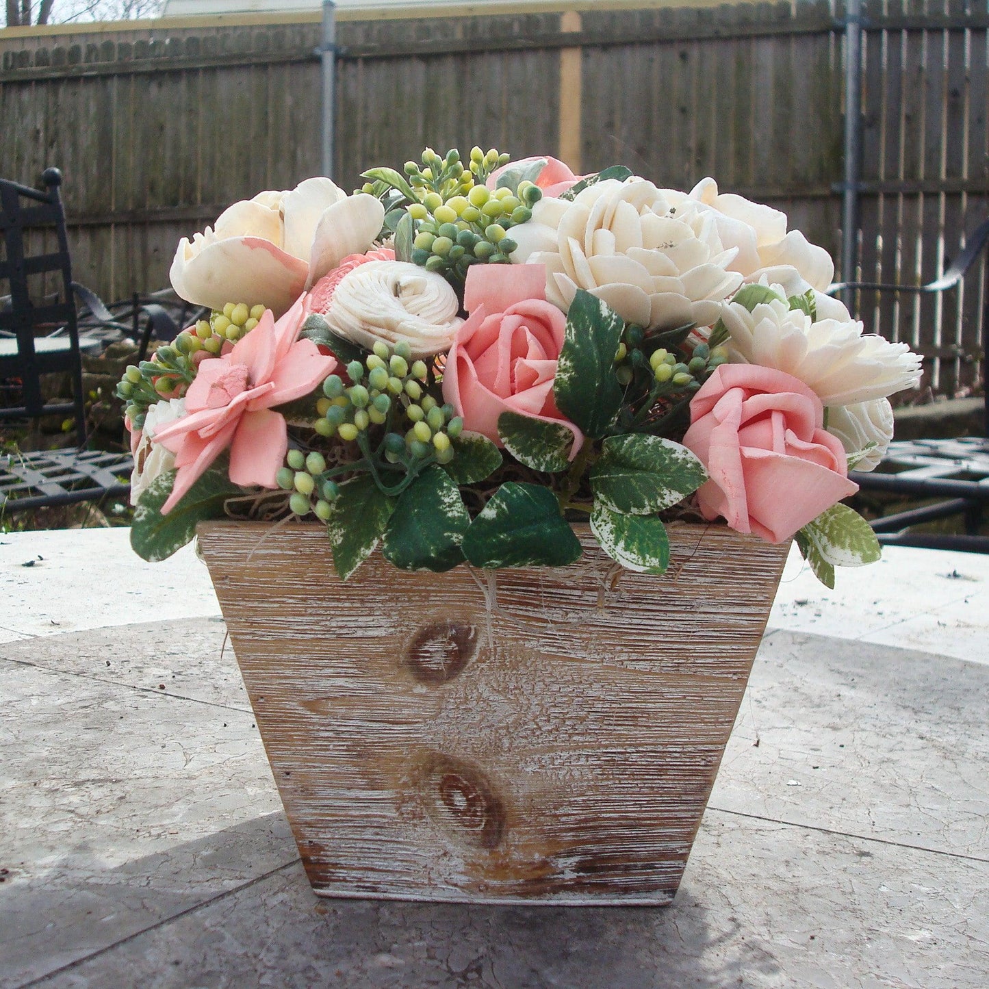 Pale pink in white Sola flowers in a  washed wood planter