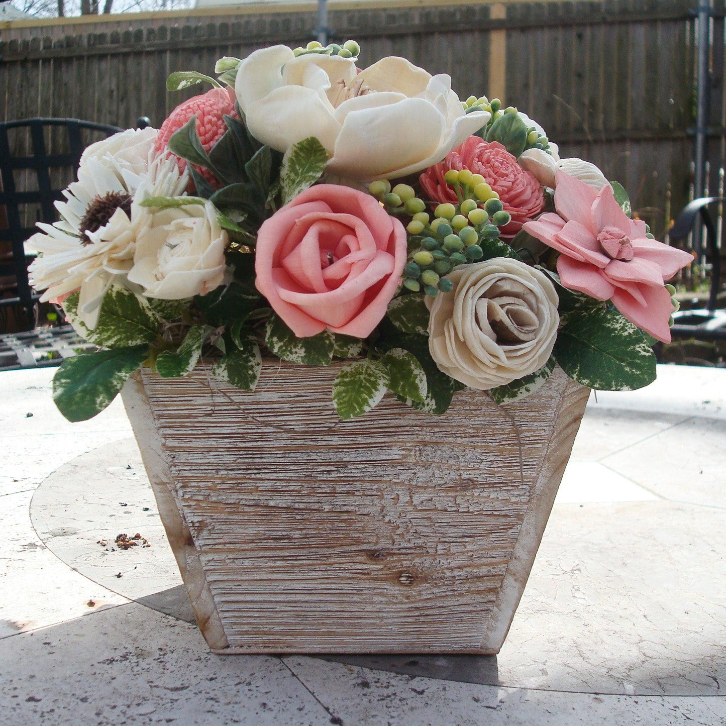 Pale pink in white Sola flowers in a  washed wood planter